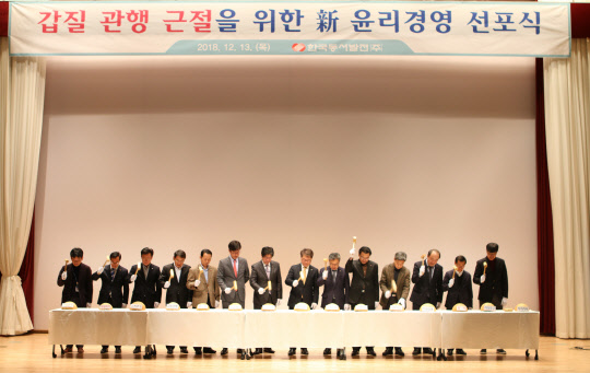 박일준 한국동서발전 사장(왼쪽 여덟번째)과 임직원들이 13일 울산 본사에서 개최한 '갑질 근절을 위한 신윤리경영 선포식'에서 '갑질 관행'을 상징하는 박을 깨는 퍼포먼스를 하고 있다. <한국동서발전 제공>